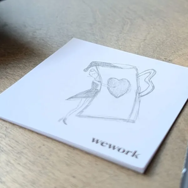 My pencil sketch on a sticky note: a woman hugging a giant coffee mug with a heart on it